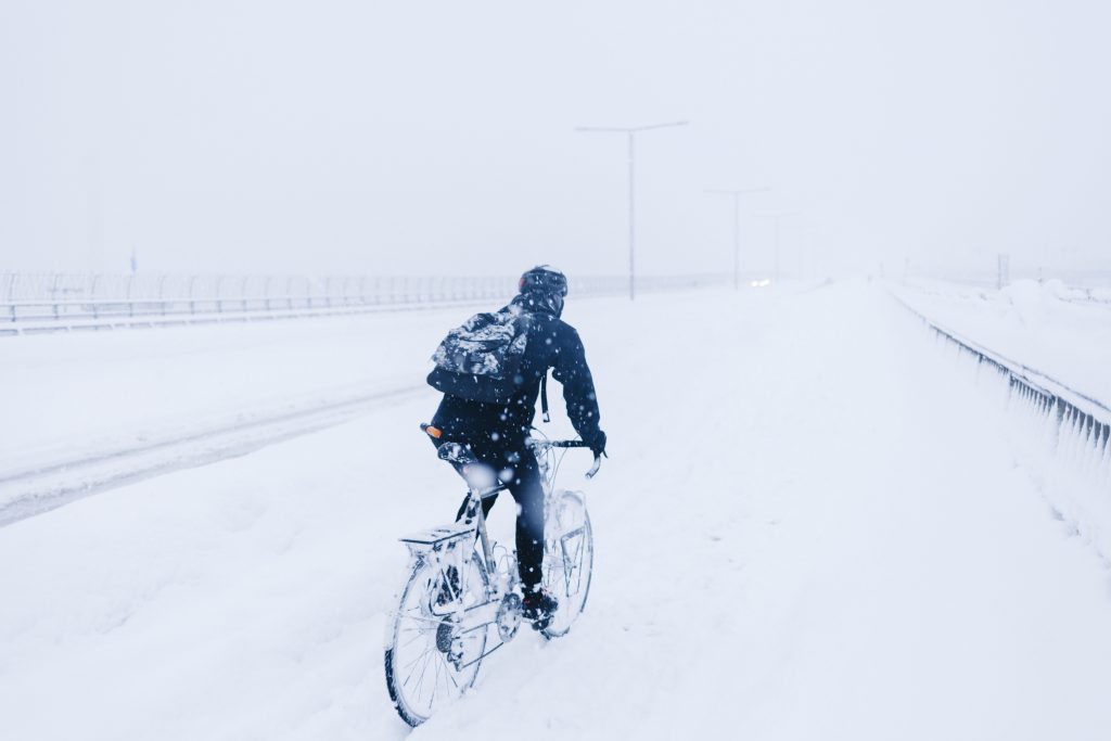 En ensam cyklist kämpar i snömassorna för att ta sig fram på en oskottad cykelbana