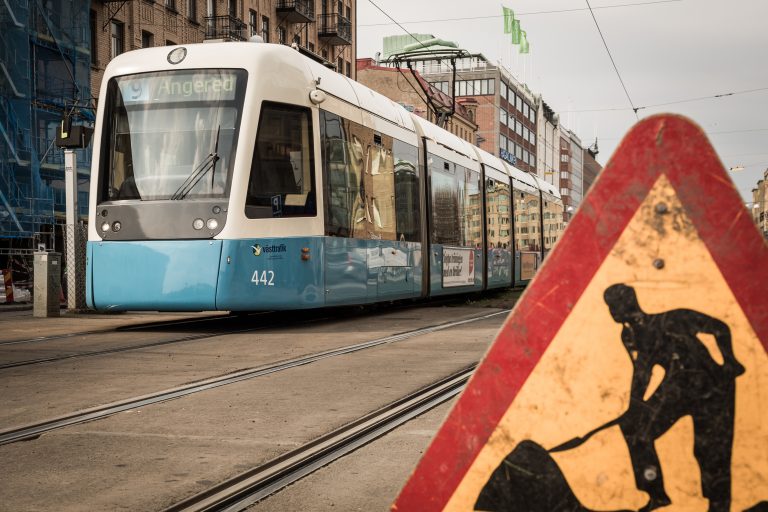 Spårvagnslinje 9 är i rörelse. Vägarbetsskylt syns i förgrunden.