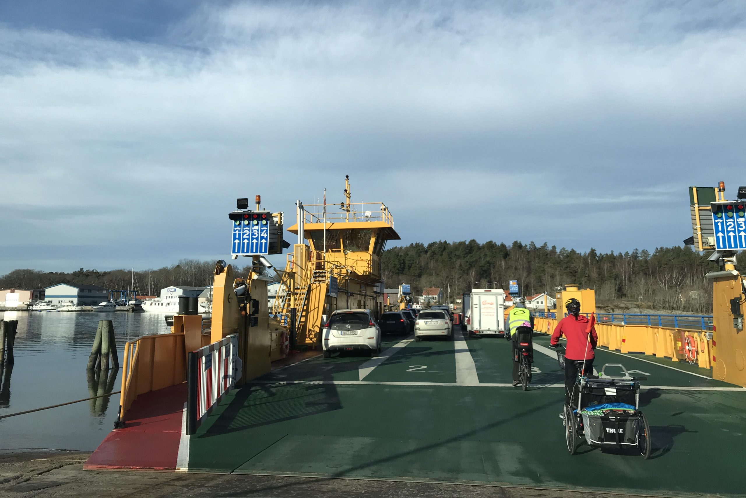 Två personbilar och en ambulans kör äver Älvsborgsbron. Pylonerna syns i bakgrunden och gång- och cykelbanan till vänster i bild.