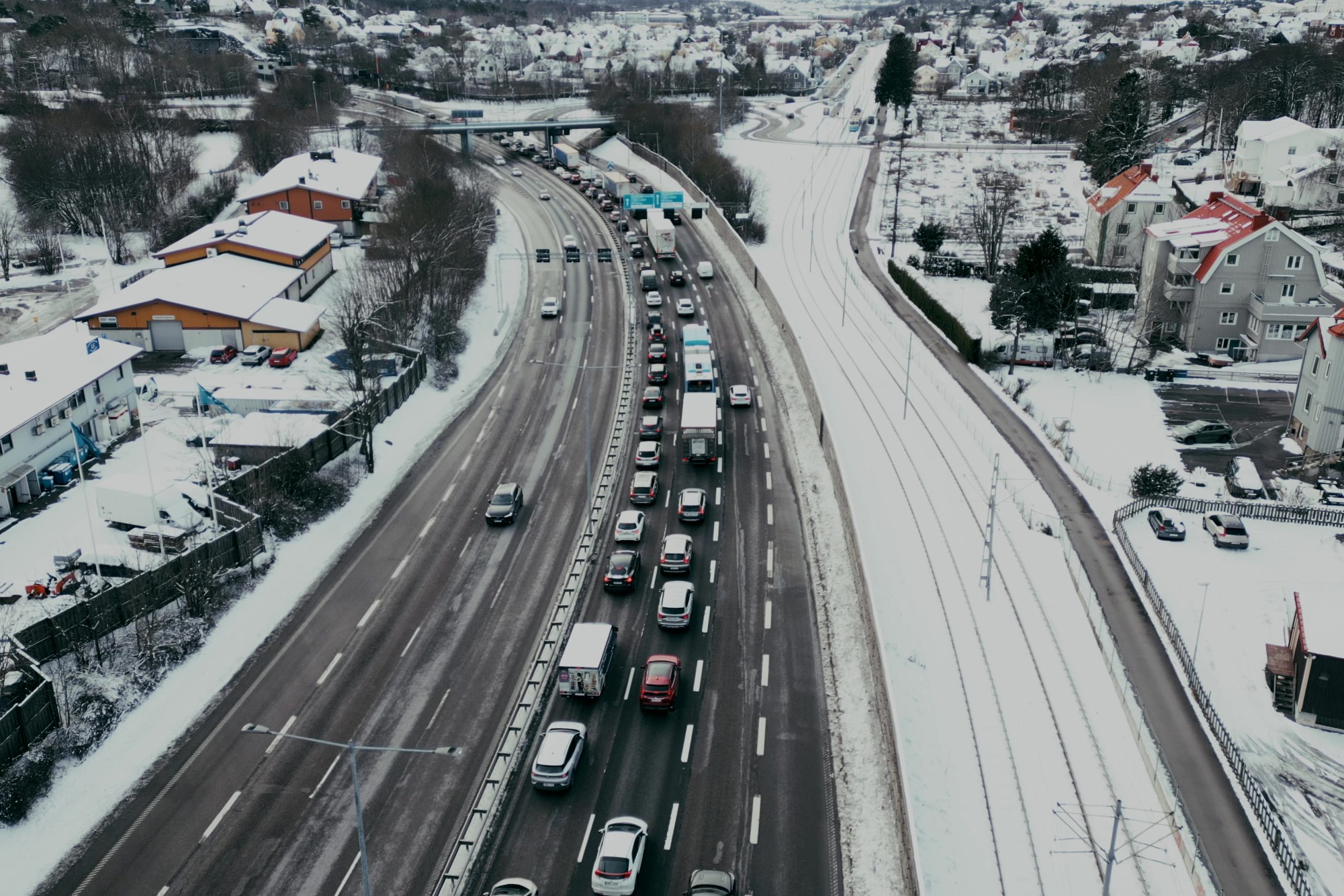 Biltrafik syns från flera håll i korsningen Hisingsgatan-Hjalmar Brantingsgatan vid Vågmästareplatsen. Dessutom står en spårvagn på perrongen.