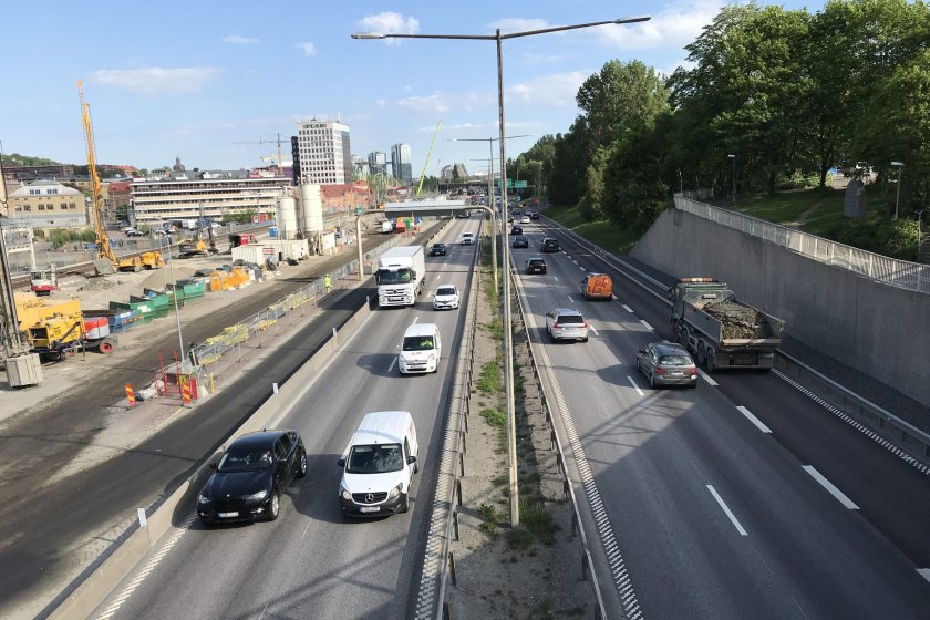 Trafiken på E6 stoppas i höjd med Kallebäcksmotet varje vardag i tio minuter mellan kl 11.20 och 11.40. Västlänkens arbetsområde syns till vänster i bild.